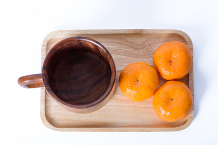 Orange and glass on  wood tray container with white backgroundの写真素材