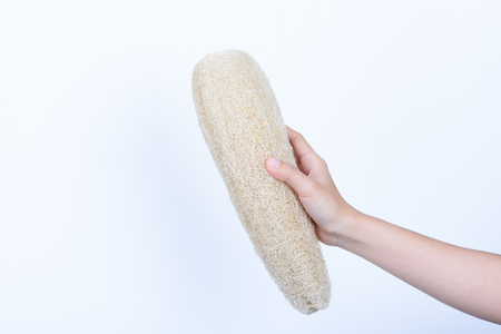 hand holding loofah zucchini natural sponge for body clean dirt and dead skin isolated on whiteの写真素材