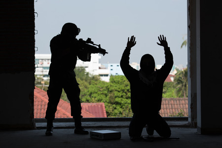 Soldier standing hand holding gun inside building structureの写真素材
