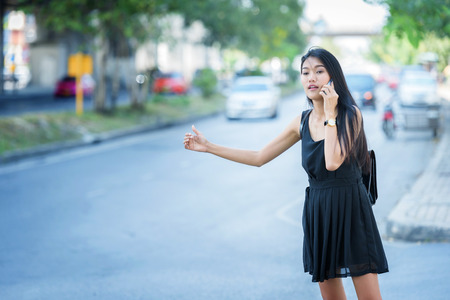 woman hand on mobile phone and wearing dress black walking on streetの写真素材