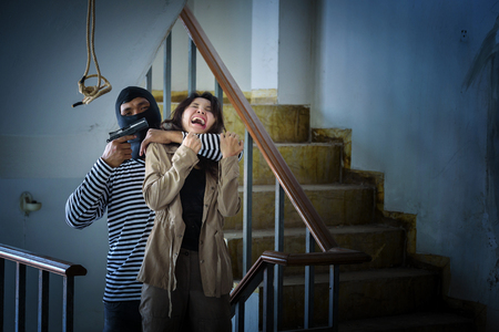 criminal hand holding shot gun woman inside building, stealth conceptの写真素材