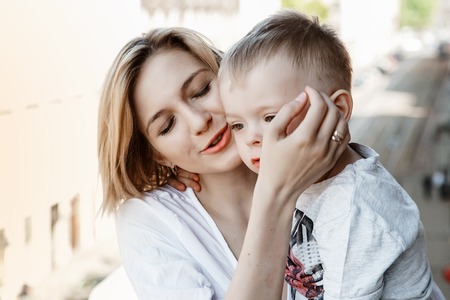 Mom hugs her baby. The boy is with his mother. A woman with her son.の写真素材
