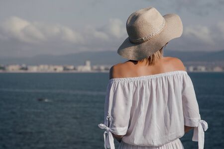 Girl in a hat is spending holidays by the sea. Young woman resting on the sea. Black Sea. Bulgaria.の写真素材