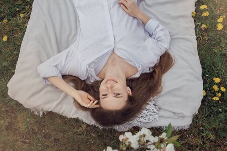 Sleep in nature. The girl is resting in a flower garden. Morning in the garden. Healthy sleep in nature. Poland garden.の写真素材