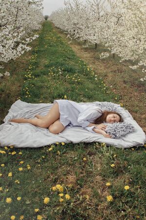 Sleep in nature. The girl is resting in a flower garden. Morning in the garden. Healthy sleep in...