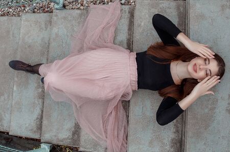 sexy girl with blond hair lying on stairs at parkの写真素材
