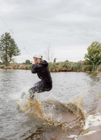 Bielawa, Polska. 03/06/2020 Wawa Wake. Young female athlete glides on water skis on the waves on the lake.のeditorial素材