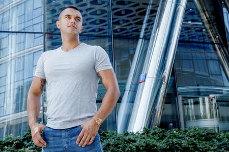 A man near a glass high-rise. Male portrait on business center background.の写真素材