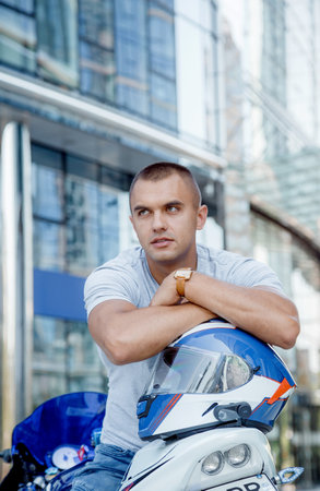 Young man on a sports motorcycle. The guy is sitting on a motorcycle. Motorcyclist. Male portraitの写真素材