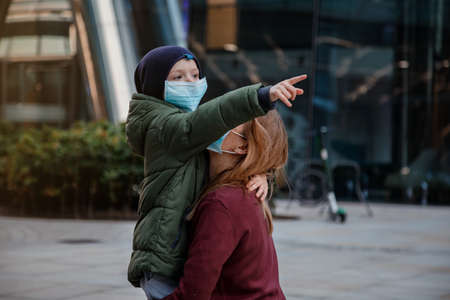 Family with kids in face mask on the street in the city. Mother and child wear facemask during coronavirus and flu outbreak.の写真素材