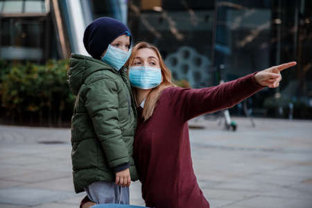 Family with kids in face mask on the street in the city. Mother and child wear facemask during coronavirus and flu outbreak.の写真素材