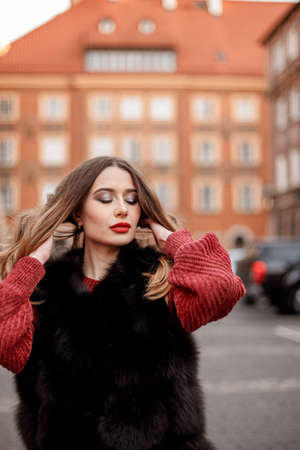 Winter holidays. Christmas concept: outdoor close up portrait of young beautiful happy smiling girl posing in street. Copy, empty space for text. Posing in street of European city. Poland. Warsaw.の写真素材