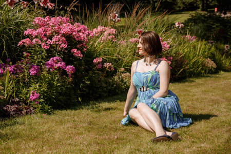 Portrait of an attractive woman gardener. Beautiful European woman in the garden near the flowers. Senior woman without makeup in the garden. Warsaw. Poland.の写真素材