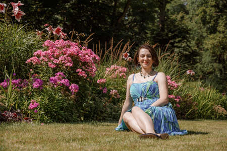 Portrait of an attractive woman gardener. Beautiful European woman in the garden near the flowers. Senior woman without makeup in the garden. Warsaw. Poland.の写真素材