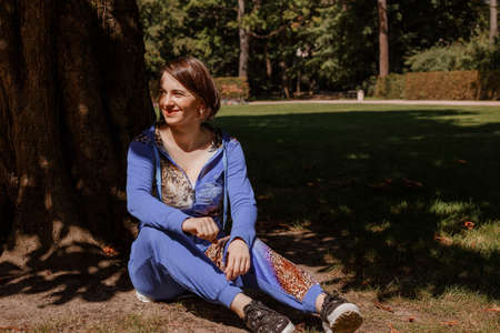 Portrait of an attractive woman gardener. Beautiful European woman in the garden near the flowers. Senior woman without makeup in the garden. Warsaw. Poland.の写真素材