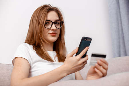 Using smartphone and credit card online shopping. Woman using mobile phone app playing game,...