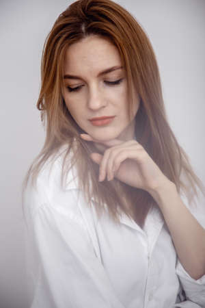 Businesswoman confident portrait. Fashion shoot of young sexy in white studio street style. Fashion photo. Caucasian female with long hair. Studio photo shoot.の写真素材