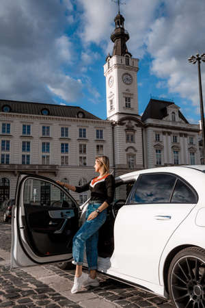 Young attractive model is sitting near the car. Girl sitting near a car. sensual girl enjoying sunset. Traveling.の写真素材
