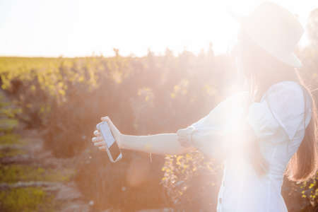 Young beautiful couple in love sitting and hugging in a green field with bushes. Walking in the...