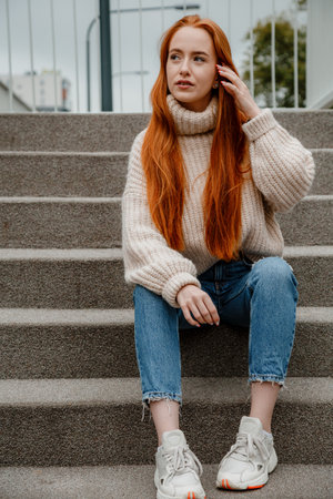 Stylish woman enjoying morning city standing on the famous green footbridge in Warsaw, Poland....