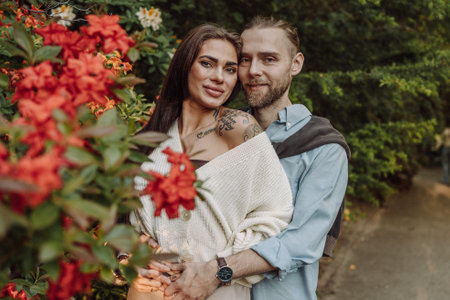 Young fun surprised couple family man woman in rest relax together boyfriend meet girlfriend. Close-up portrait of a girl with a freckled face standing and hugging his neck in the sunlight. Botanic Garden.の写真素材
