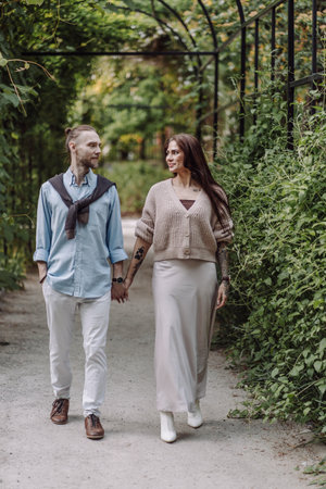 Copy space. overs are laughing. Happy guy and girl. Lovers enjoy each other in the evening park. Young couple strolling in the park. Happy romantic moments of lovely couple in park during dating.の写真素材