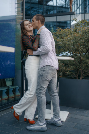 Romantic scene of a couple of lovers sitting at a table outside a cafe. The man and woman are...