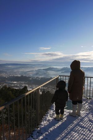Mother and son on balcony looking at beatiful landscapeの写真素材
