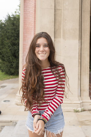 Beautiful casual woman with long hair posing at camera, outdoor.の写真素材