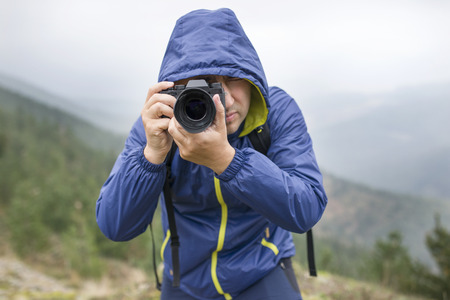 Man hiking in the mountains photographing nature.の写真素材