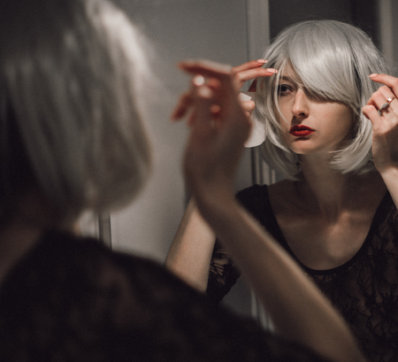 Beautiful, attractive and young girl is doing a morning makeup. Woman with blond hair in bathroom. Cosmetics and skincare concept. の写真素材