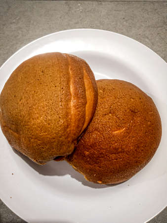 Delicious coffee-flavored bread on a white round plate that is placed on a gray wooden table, very suitable for eating to endure hungerの写真素材