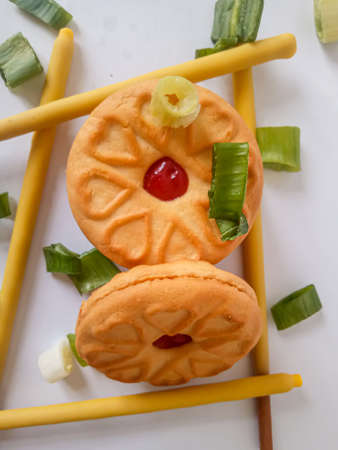 Yellow round biscuits, medium size, are decorated with green onions, these biscuits are perfect for snacking with family.の写真素材