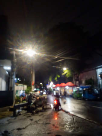 A view of a city street in the middle of a quiet night, people who make a living at night are working and also cars coming home from workの写真素材