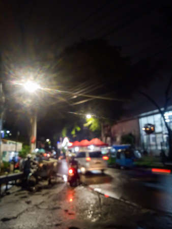 A view of a city street in the middle of a quiet night, people who make a living at night are working and also cars coming home from workの写真素材