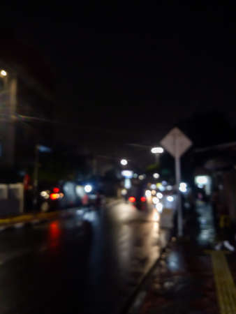 A view of a city street in the middle of a quiet night, people who make a living at night are working and also cars coming home from workの写真素材