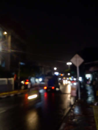 A view of a city street in the middle of a quiet night, people who make a living at night are working and also cars coming home from workの写真素材