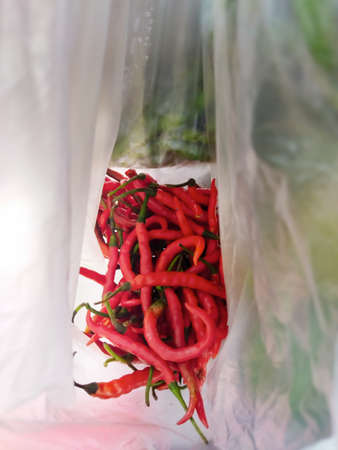 Fresh long red chilies, making food spicy, the chilies are below the market and sold by peddlers in Jakarta, Indonesiaの写真素材