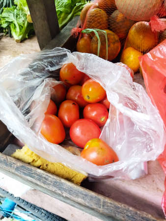 Fresh tomatoes are ripe below from the market and sold by mobile traders in Jakarta, Indonesiaの写真素材