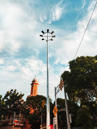 High street lamp, in the middle of the main road, many trees beside it, and a mosque behind it.の写真素材