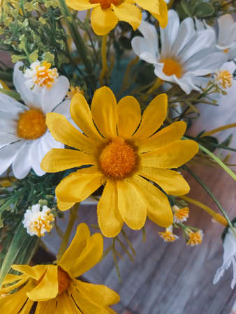Yellow flowers that are located on the table are used to make the table look more beautiful and not empty.の写真素材