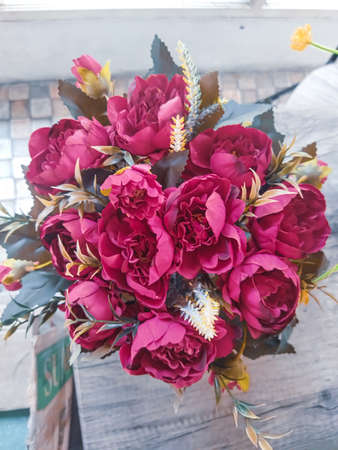 Red flowers that are located on the table are used to make the table look more beautiful and not empty.の写真素材