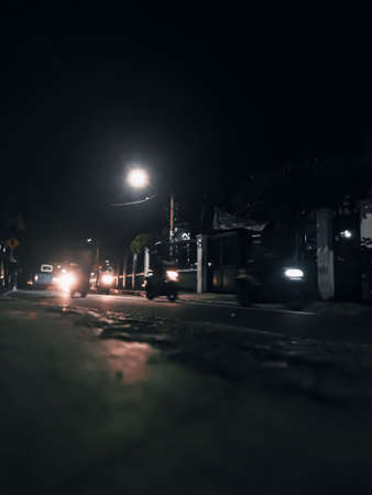 Night streets in Jakarta Indonesia, are full of 2 and 4 wheeled vehicles such as cars and motorbikes.の写真素材