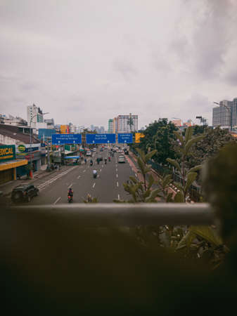 A long and straight highway in Jakarta Indonesia as seen from above the bridge, on the right side there are shady trees that grow well.のeditorial素材