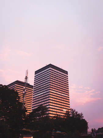 An office building or apartment that chooses an attractive building design and looks beautiful when exposed to the sunset.の写真素材