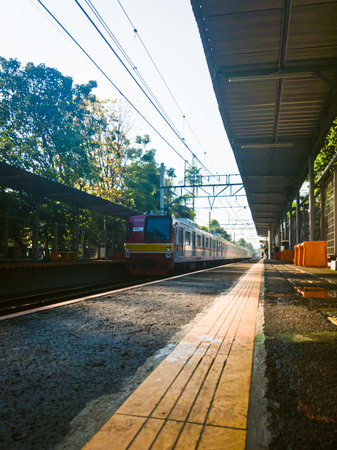 Central Jakarta, Indonesia - March 28th, 2021: The red KAI train slowed its speed because it wanted to stop for a moment at the station.のeditorial素材