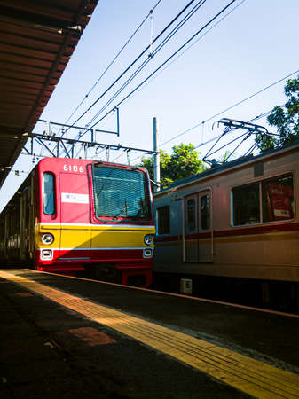 Central Jakarta, Indonesia - March 28th, 2021: The red KAI train slowed its speed because it wanted to stop for a moment at the station.のeditorial素材