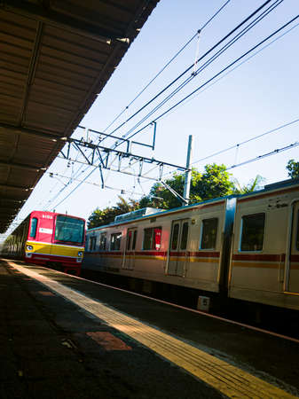 Central Jakarta, Indonesia - March 28th, 2021: The red KAI train slowed its speed because it wanted to stop for a moment at the station.のeditorial素材