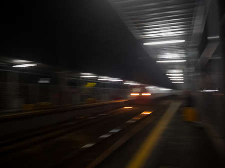 The train came to pick up passengers at night at the train station.