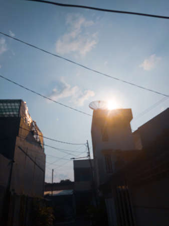 The beauty of the sky and the sun in the hallway of the residents' housesの写真素材